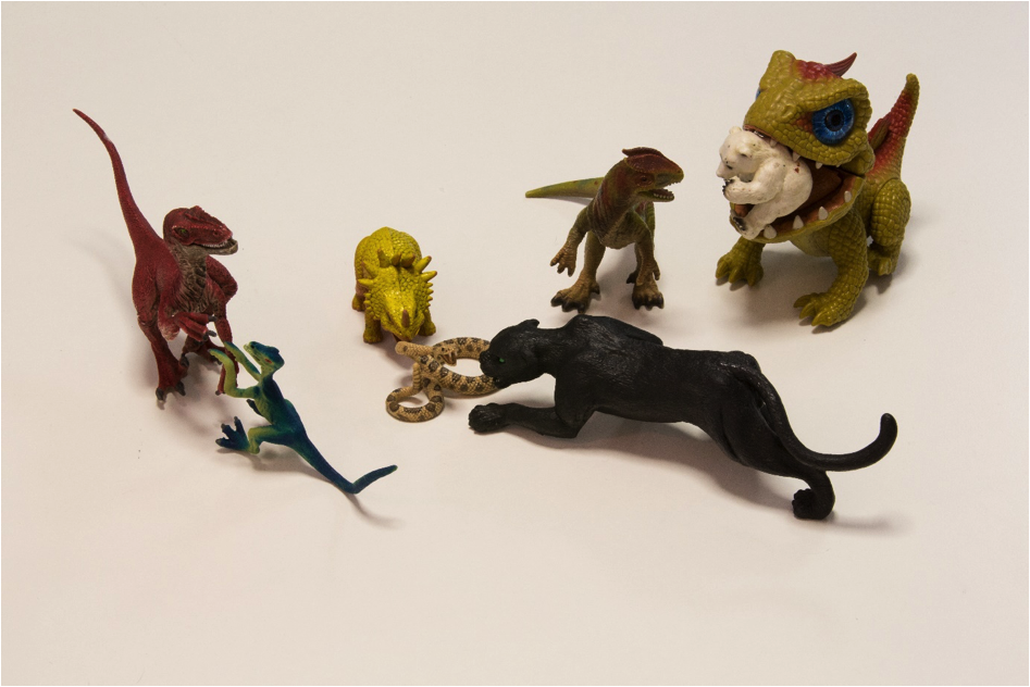 Spielzeugfiguren von Dinosauriern, Schlange und Panther als Sinnbild für die 7 Energieräuber